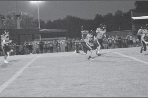 Staff Photo by Bill Anderson The Wewoka Tigers quarterback Tanner Johnston gets the ball to wide receiver Cameron Campbell for the first down Friday night.