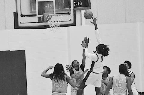Seminole State Trojan Jaylan Jackson goes up and over the Langston defenders for the shot. Staff Photo by Bill Anderson