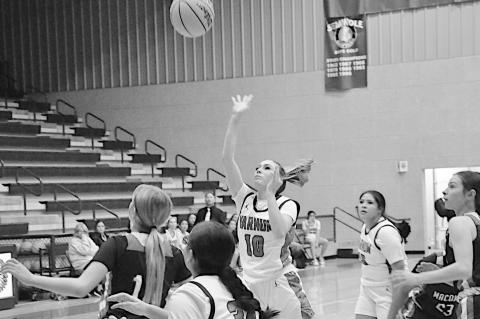 Varnum Lady Whippet Ashlyn White-Richards shoots over the Macomb defenders Monday night at the LRC Tournament. Varnum won 53-34. Staff Photo by Bill Anderson