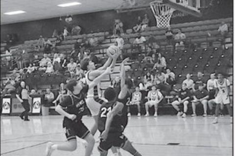 Konawa Tiger Tristan Lankford goes in between some Wewoka defenders for the shot Monday. Staff Photo by Bill Anderson