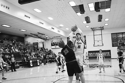 Konawa Tiger Adonis Kiser goes over his defender for the basket. Staff Photo by Andy Wilson