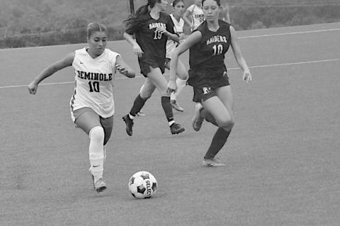 Seminole State Lady Trojan Delilah Rico gets the ball past the Rose State defender. Staff Photo by Bill Anderson