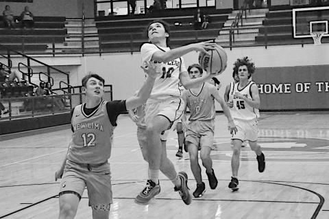 Bowlegs Bison Cayxon Parson flies in for the shot guarded by New Lima Falcon Logan Peffley at the LRC Tourney Monday night. New Lima won 35-31. Staff Photo by Bill Anderson