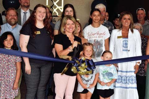 Tanya Friend of Stuart &amp; Clover Title in Seminole cuts the ribbon during open house ceremonies Wednesday afternoon. Others pictured include Dakota Jones, Mila Meeks, Wilo Meeks and Juliana States. The company is located at 205 N. Main. —Staff Photo 