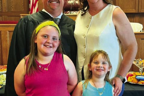 Far left, Special Judge Ryan Pitts was administered the oath office on May 15 by District Judge Brett Butner (right) as Pitts’ wife, Hillary, holds the Bible. Pictured at left is Pitts with his wife and daughters, Rylee and Reagan. The family makes thei