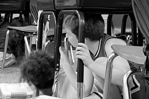 Fourth-grade students at Plaza Towers Elementary School in Moore practice Drop, Cover and Hold On under their desks during an earthquake safety presentation by the Oklahoma Geological Survey on Wednesday, Oct. 9, 2024. (Photo provided)