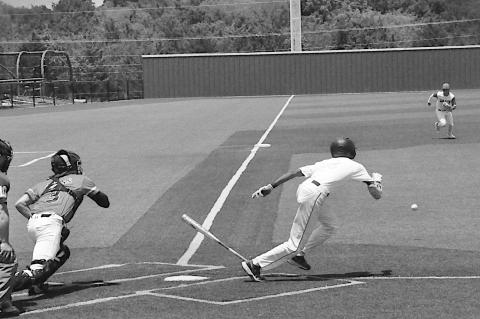 Diamond Dawgs player bunts the ball and races to first base Friday afternoon during Showdown. Staff Photo by Bill Anderson