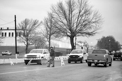 On days when the state executes an inmate, barricades block access to the Oklahoma State Penitentiary in McAlester. A guard is seen walking near one of the barricades a few hours before the state executed Gilbert Postelle on Feb. 17, 2022. (Whitney Bryen/