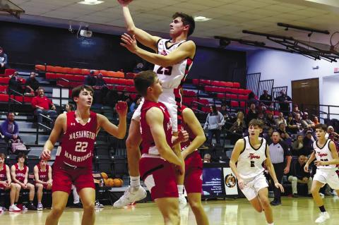 Konawa’s Zackary Reavis leaps high between two defenders