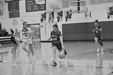 Bowlegs Lady Bison Kasin Kolander drives the ball down field against Macomb defender. Bowlegs lost 27-51. Staff Photo by Bill Anderson